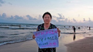 Women's rights activist, Ye Hiayan (AKA Hooligan Sparrow), holds a sign which reads, "All China Women's Federation is a Farce. China's Women's Rights are Dead."